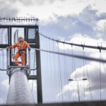 Bridge worker on cable of suspension bridge. The Humber Bridge, UK was built in 1981 and at the time was the worlds largest single-span suspension bridge